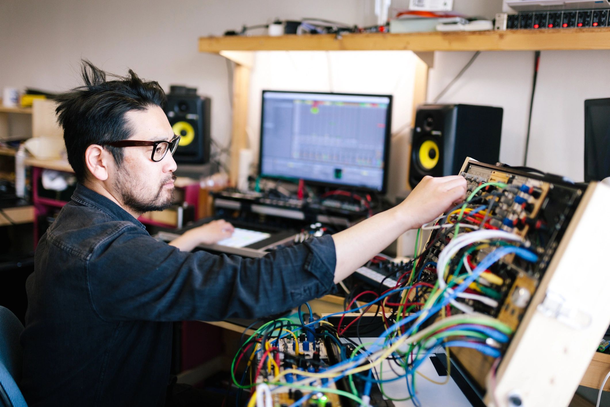 Engineer working with electronic music equipment in a studio